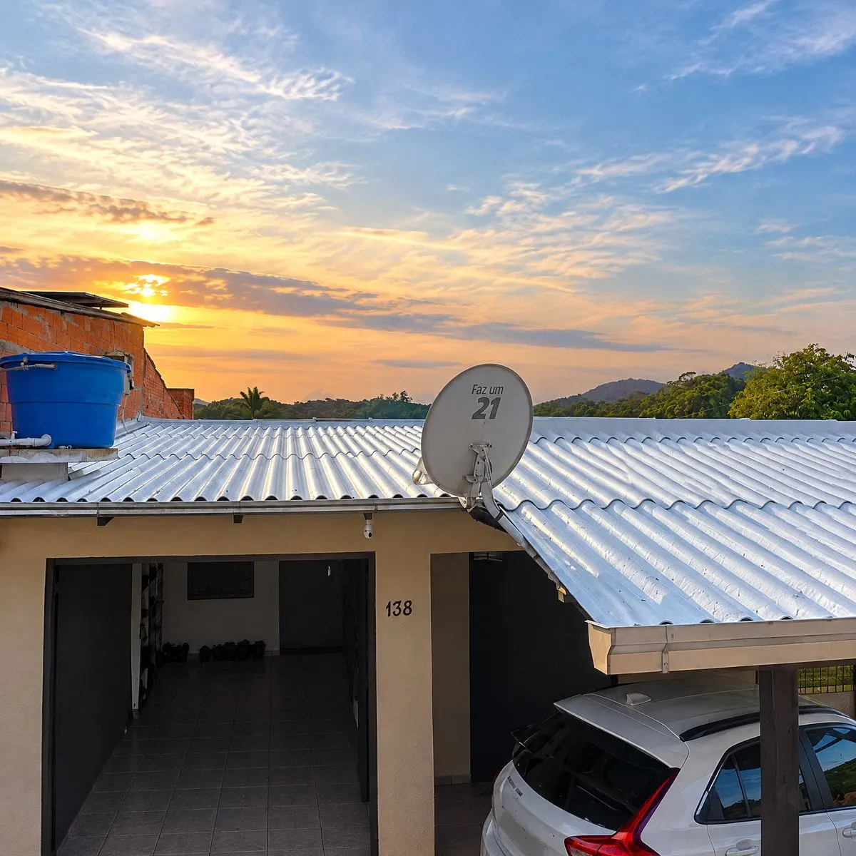 Telhado metálico ondulado impermeabilizado com vista para o pôr do sol e antena