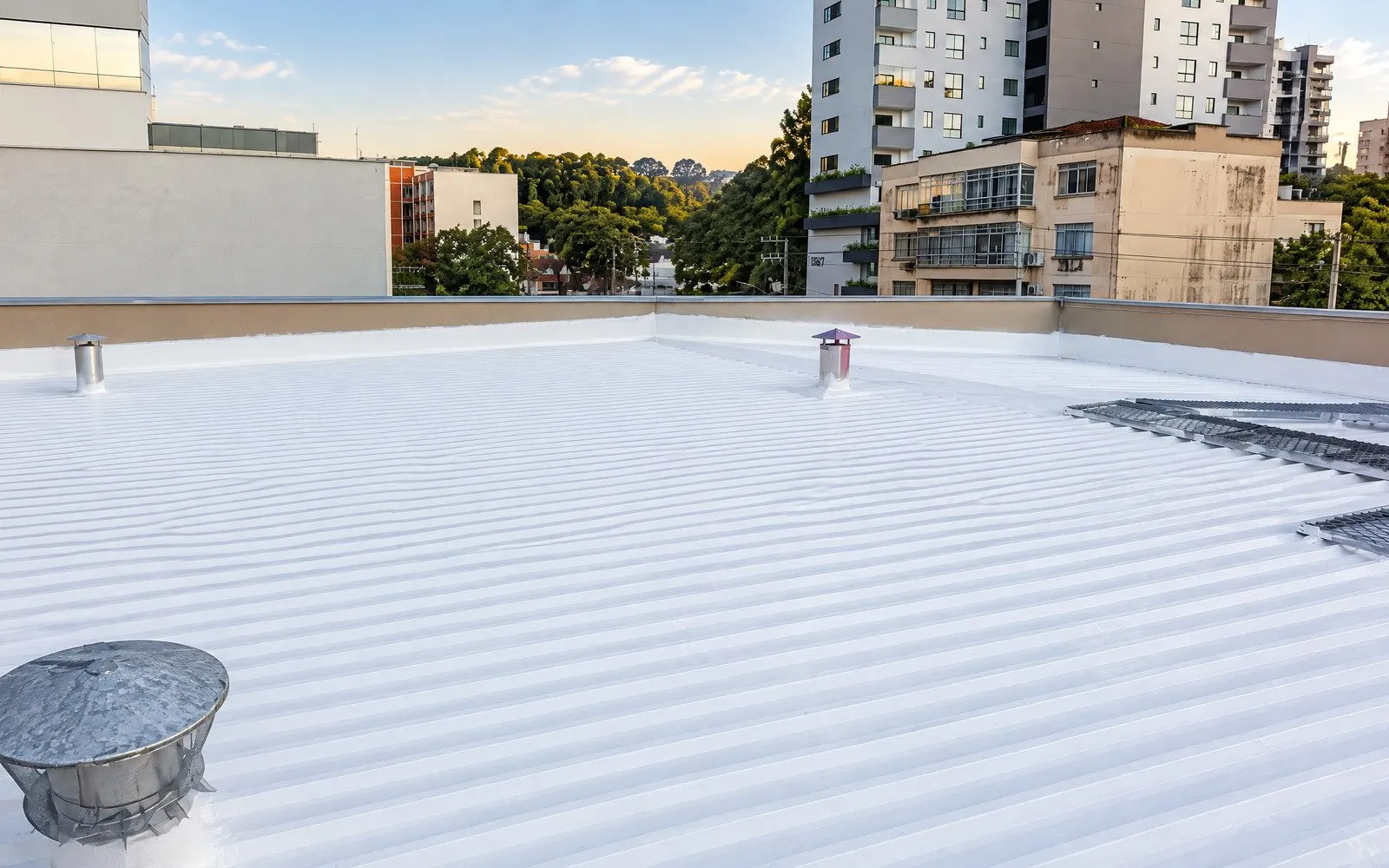 Laje/cobertura com acabamento refletivo branco ao entardecer em área urbana